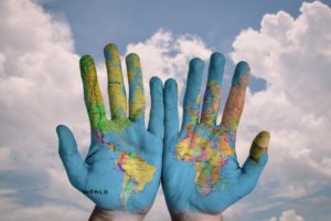 Stock image of hands with a world map painted on them