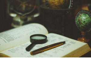 Book, pen and magnifying glass photo