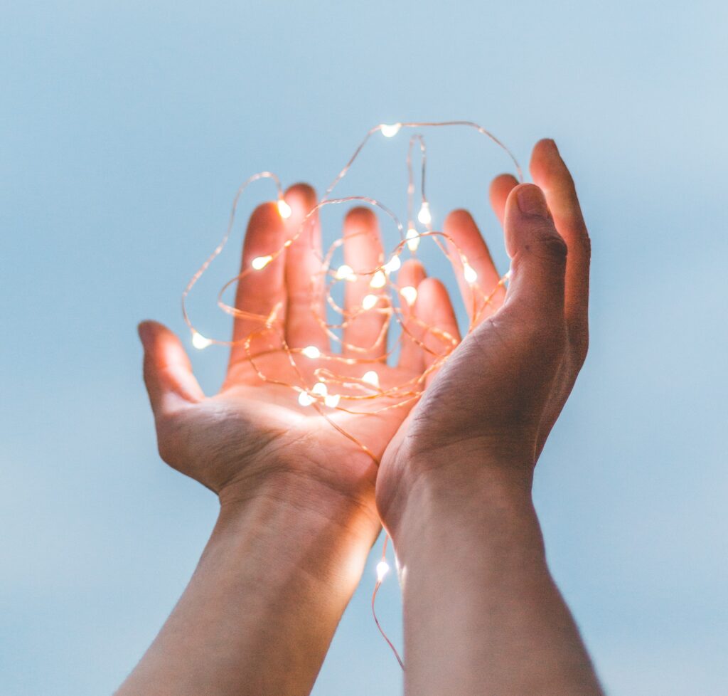 Pair of hands holding out a wire of light