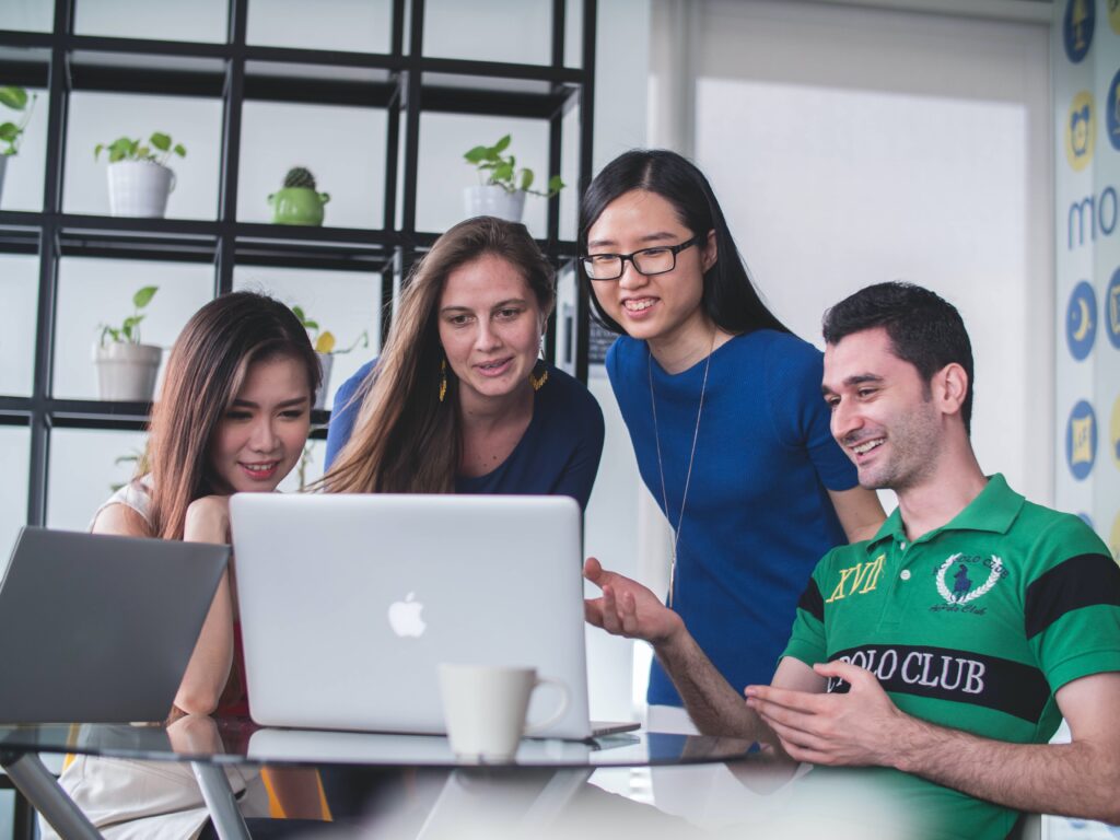 4 students gathered around a laptop
